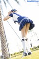 A woman in a blue and white uniform is standing in the grass.