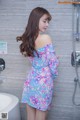 A woman standing in a bathroom next to a bathtub.