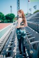 A woman standing in a stadium with her back to the camera.