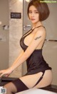 A woman in a black lingerie sitting on a counter.
