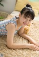 A woman laying on a bed with a teddy bear.