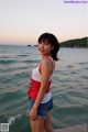 A woman standing on a pier near the ocean.